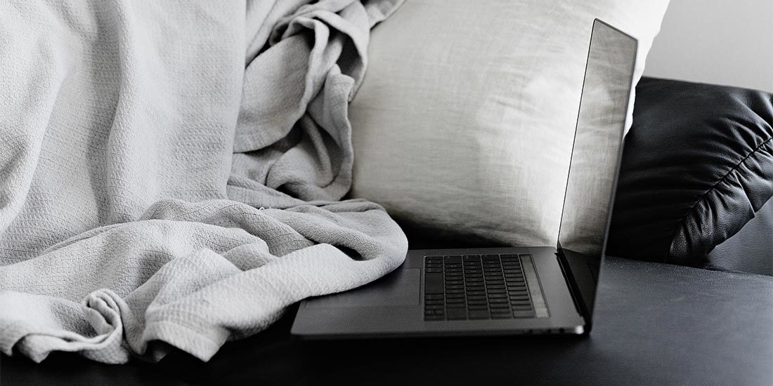 Homeoffice: grauer Laptop liegt auf einem Sofa