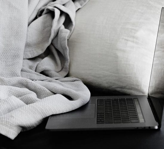 Homeoffice: grauer Laptop liegt auf einem Sofa